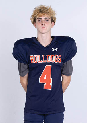 A young man wearing a white and black jersey with the number 14 on it. Description generated by AI