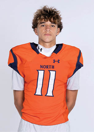 A young man wearing a white and black jersey with the number 14 on it. Description generated by AI