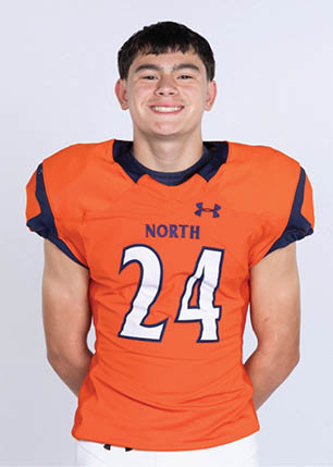 A young man wearing a white and black jersey with the number 14 on it. Description generated by AI