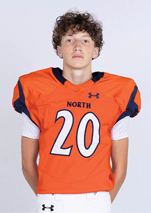 A young man wearing a white and black jersey with the number 14 on it. Description generated by AI