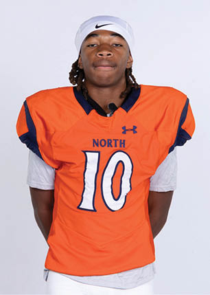 A young man wearing a white and black jersey with the number 14 on it. Description generated by AI