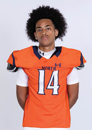A young man wearing a white and black jersey with the number 14 on it. Description generated by AI
