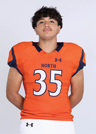 A young man wearing a white and black jersey with the number 14 on it. Description generated by AI