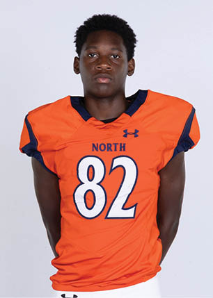 A young man wearing a white and black jersey with the number 14 on it. Description generated by AI