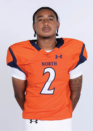 A young man wearing a white and black jersey with the number 14 on it. Description generated by AI