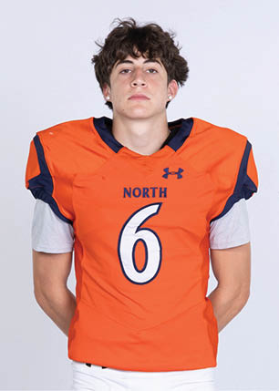 A young man wearing a white and black jersey with the number 14 on it. Description generated by AI