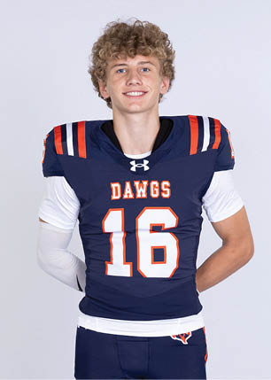 A young man wearing a white and black jersey with the number 14 on it. Description generated by AI