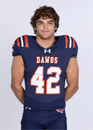 A young man wearing a white and black jersey with the number 14 on it. Description generated by AI