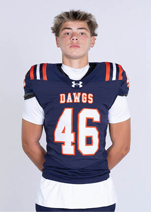 A young man wearing a white and black jersey with the number 14 on it. Description generated by AI