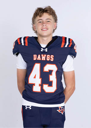 A young man wearing a white and black jersey with the number 14 on it. Description generated by AI