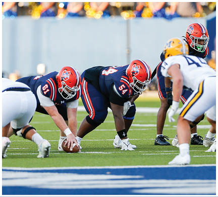 A football player running on the field. Description generated by AI