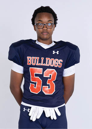 A young man wearing a white and black jersey with the number 14 on it. Description generated by AI