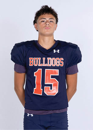 A young man wearing a white and black jersey with the number 14 on it. Description generated by AI