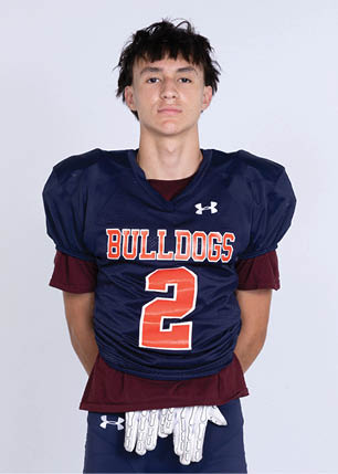 A young man wearing a white and black jersey with the number 14 on it. Description generated by AI