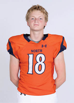 A young man wearing a white and black jersey with the number 14 on it. Description generated by AI