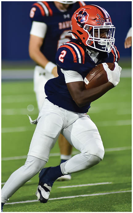 A football player running on the field. Description generated by AI