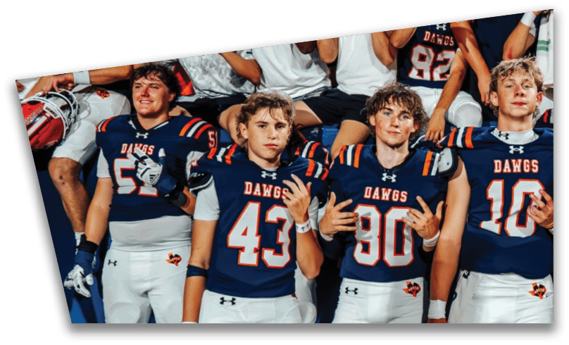 People wearing black American Canyon football uniforms and helmets are standing on a football field at night. Description generated by AI
