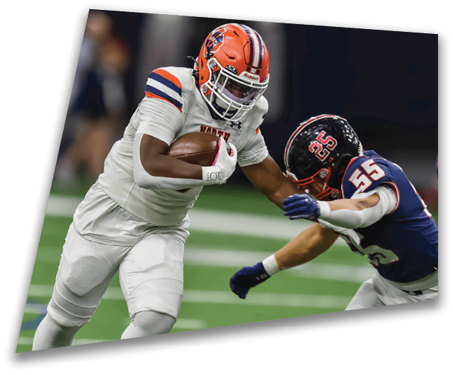 Four people in dark football uniforms and helmets stand in a row on a field, appearing focused and ready for action. Description generated by AI