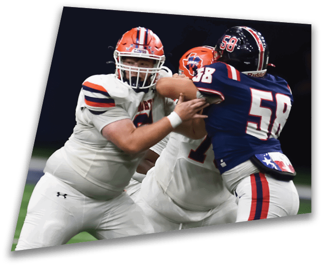 Four people in dark football uniforms and helmets stand in a row on a field, appearing focused and ready for action. Description generated by AI