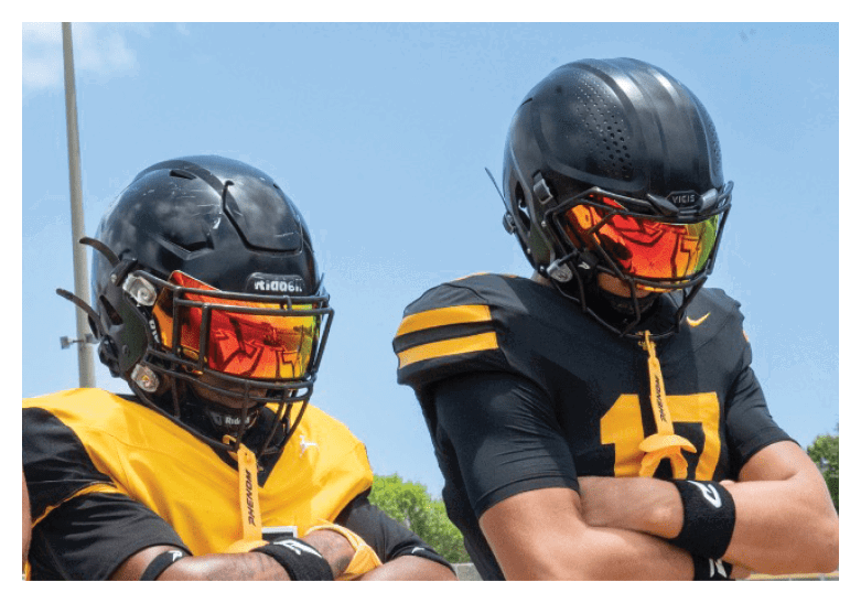 A group of football players on a field, one of them is running with a football. AI generated content