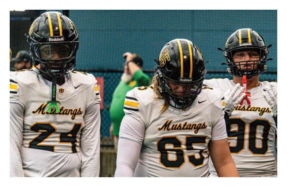 A group of football players wearing headphones and smiling. AI generated content