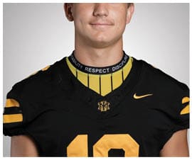 A person wearing a black and yellow sports jersey with the number 18 and a collar that has the words agility, respect, and discipline. Description generated by AI