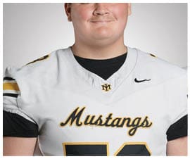 A person wearing a white football jersey with “Mustangs" written on the front and a black undershirt is shown from the shoulders up. Description generated by AI