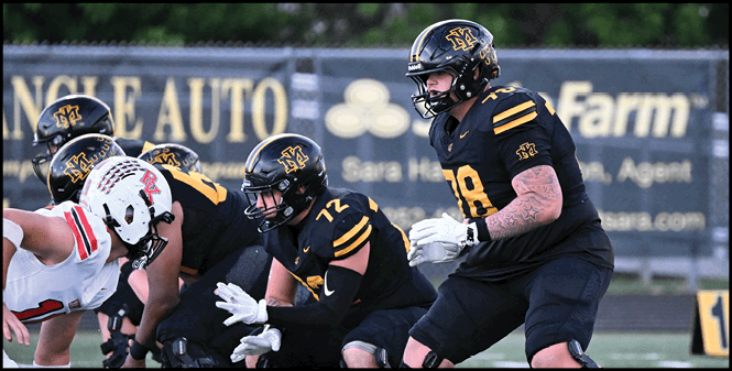 Several people in football uniforms are lined up on a field preparing for a play during a game. Description generated by AI
