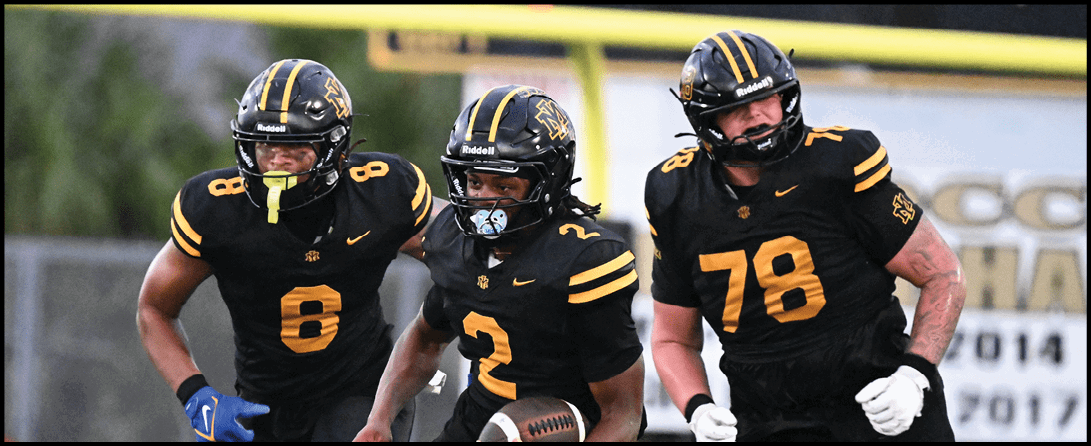 Three people wearing black and yellow football uniforms with helmets are running on a field, with one holding a football. Description generated by AI