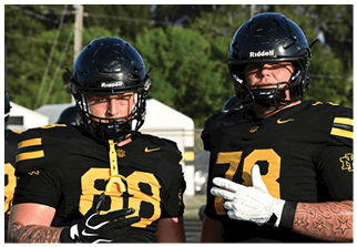 Two football players wearing blue and white uniforms. Description generated by AI