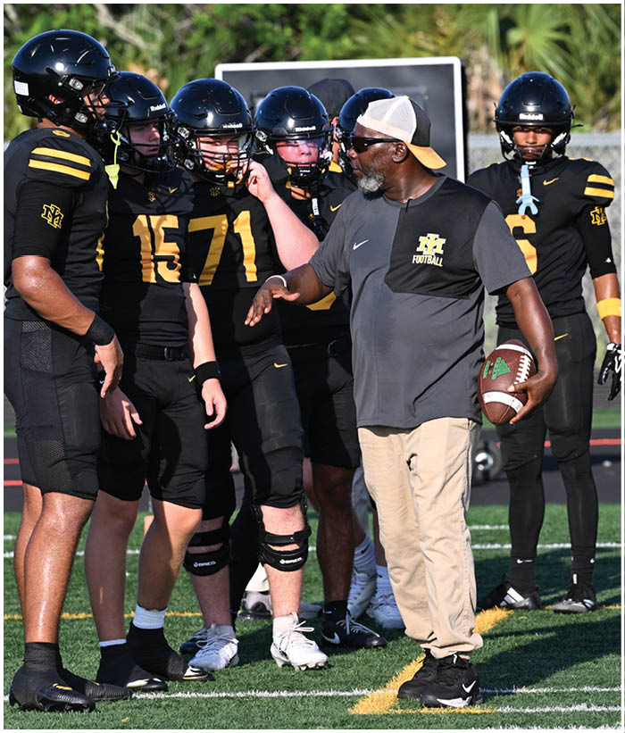 A group of football players wearing black and white uniforms. Description generated by AI