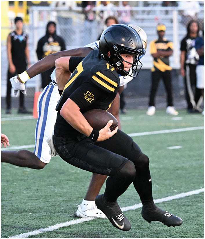 A group of football players wearing black and white uniforms. Description generated by AI