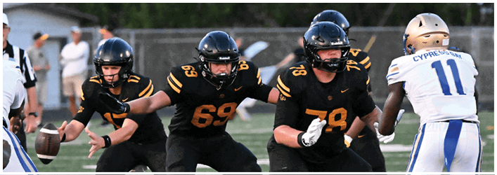 A group of football players on a field. Description generated by AI