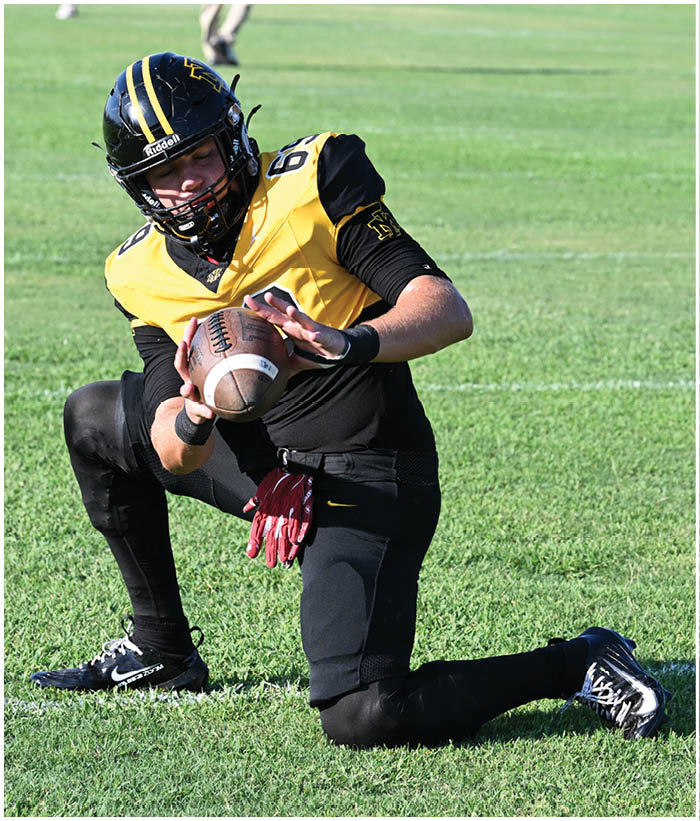 A group of football players wearing black and white uniforms. Description generated by AI