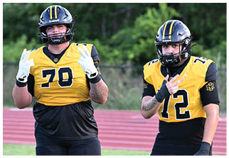 Two football players wearing blue and white uniforms. Description generated by AI