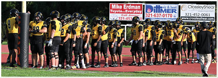 A group of football players on a field. Description generated by AI