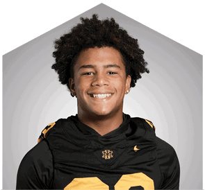 A young man wearing a white jersey with the number 10 on it. Description generated by AI