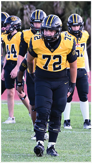 Two football players wearing blue and white uniforms. Description generated by AI