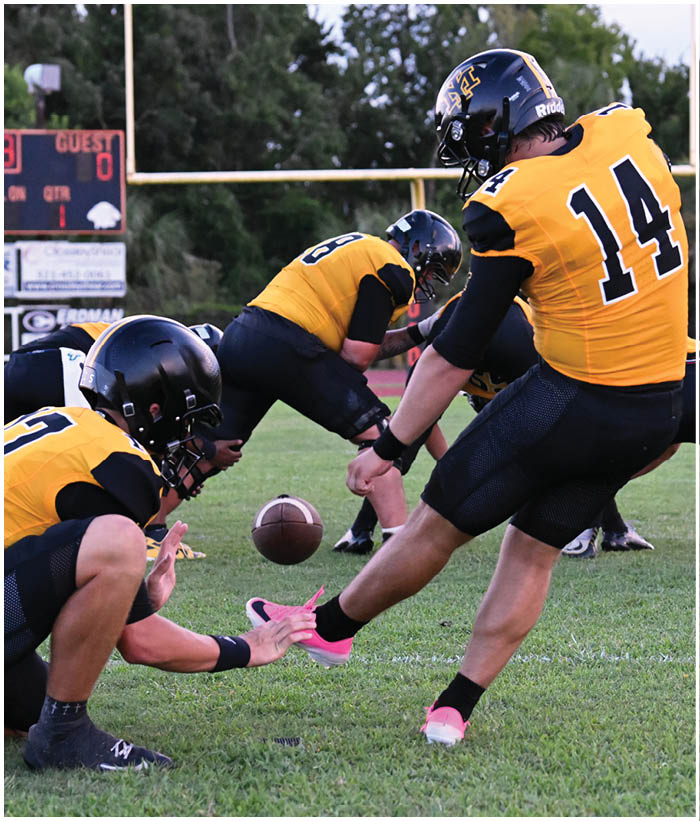 A group of football players wearing black and white uniforms. Description generated by AI