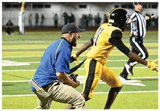 Two football players wearing blue and white uniforms. Description generated by AI