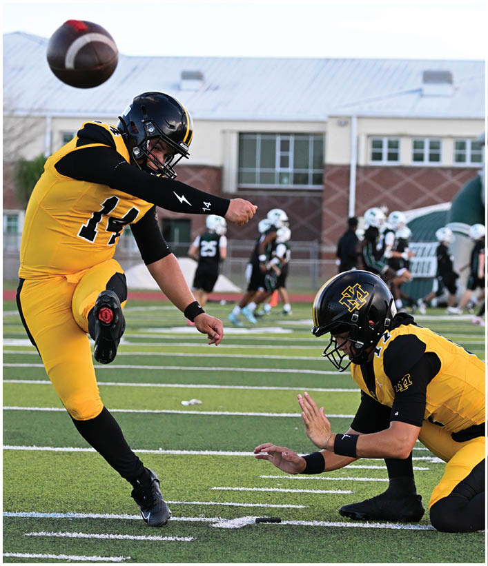 A group of football players wearing black and white uniforms. Description generated by AI