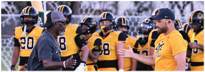 A group of football players on a field. Description generated by AI