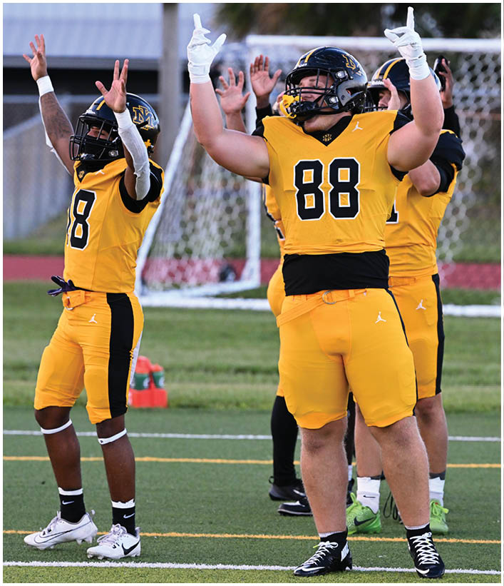 A group of football players wearing black and white uniforms. Description generated by AI