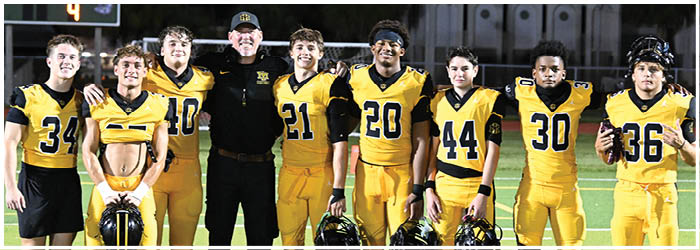 A group of football players on a field. Description generated by AI