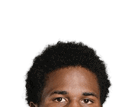 Person with short curly hair looking directly at the camera against a white background. Description generated by AI