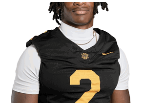 Person wearing a black sports jersey with the number two and a white undershirt with a chain necklace. Description generated by AI