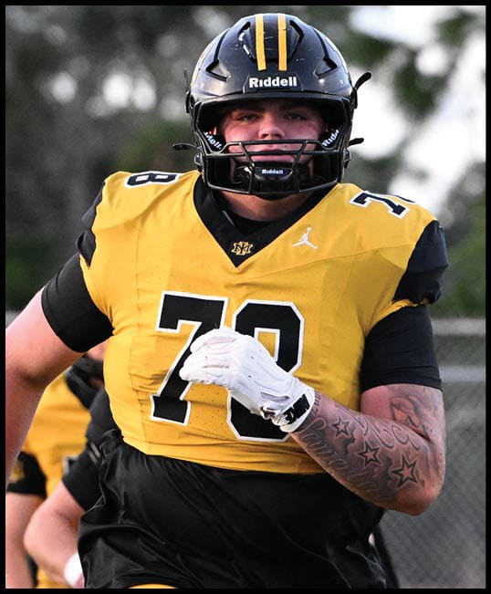 A person wearing a yellow and black football uniform with the number 78 is running on a field with a helmet and gloves. Description generated by AI