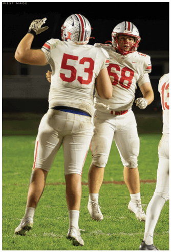 A person wearing a white football uniform with the number 53 and a helmet covered in white stickers is raising one hand against a dark background. Descripci n generada con IA