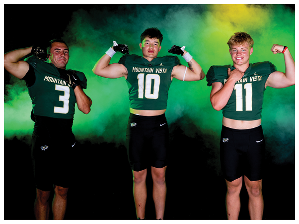 Three people wearing Mountain Vista football uniforms flex their arm muscles against a smoky green and yellow background. Description generated by AI