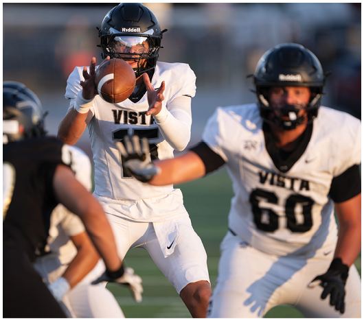 A person wearing a black helmet and a white football jersey with the number 60 and the word Vista is on a sports field. Description generated by AI